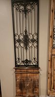 Photo of large wall panel with distressed wood bottom and intricate black metal decorative upper section.
