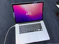 Laptop open showing screen displaying welcome screen and keyboard/trackpad.