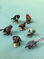 Seven Beswick porcelain bird figurines arranged on a green surface showing full top view.