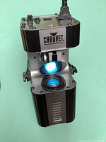 Front and top view of one Chauvet Intimidator light showing blue LED beam and motorized mirror system.