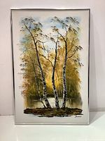 Full view of the oil painting showing birch trees with a water background and foliage framed in brushed aluminum.