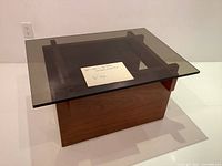 Front three-quarter view of teak base and smoked glass top