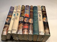 Nine vintage Nancy Drew mystery books in a row showing spines with titles, author Carolyn Keene, and publisher Grosset & Dunlap.
