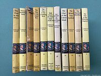 Photo shows spines of 11 yellow matte Nancy Drew mystery books with titles, volume numbers, author Carolyn Keene, and Grosset & Dunlap publisher logos.