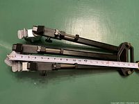 Top view of tripod dolly folded with measuring tape showing about 22 inches length on one arm.