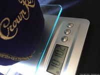Digital scale displaying weight of 10 lbs 10.2 oz with Crown Royal bag partially visible on top of scale.