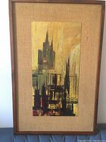 Front view of vintage mid century modern abstract wall art with wooden frame and textured fabric background.