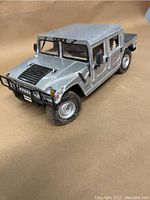 Front angle view of silver die cast Hummer model showing hood vents, front grille guard, tires and detailed bodywork.
