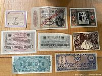 Top view of 8 paper money notes laid flat showing different countries and denominations.