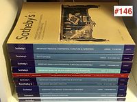 Photo showing stacked Sotheby's and Christie's auction catalogues with spines facing out, highlighting their titles and auction dates.