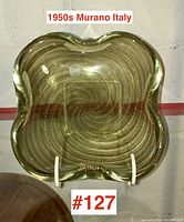 Straight-on front view of olive green Murano glass bowl with gold inclusions showing square wavy edges and swirling gold flecks