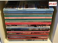 Stack of 25 auction catalogues with a range of colors and sale numbers visible on spine.