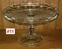 Front side view of the clear glass EAPG pedestal plate showing scalloped edges and octagonal pedestal base.
