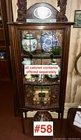 Full front view of the Edwardian mahogany display cabinet showing the leaded glass door and interior contents (contents not included).