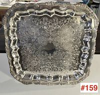 Top-down view of the large square silver plated footed tray showing the engraved design and scalloped edges.