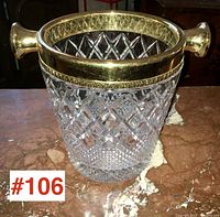 Front view of the vintage crystal champagne bucket showing diamond cut crystal body and gold-tone mount with handles.