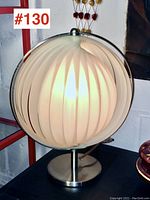 Front view of vintage IKEA spherical pleated shade table lamp illuminated.