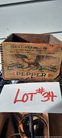 Full view of wooden dovetailed pepper box with visible aged paper label on one end showing company and product details.