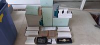 Full view of stacked PartyLite and Avon product boxes on table.