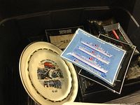 Photo showing stack of plates and ashtrays with various logos including Rockville Crushed Stone and Carnival Cruise Lines.