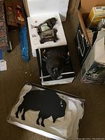 Photo of three items: Bradford Exchange buffalo figure in styrofoam, black metal buffalo silhouette wall hanging, and buffalo head plaque on black base