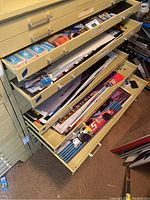 Overview of open drawers containing stacks of posters and playing cards