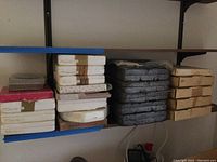 Stack of thirty boxed plates on shelves including paper, cardboard and Styrofoam boxes