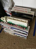 Top view of Hess white and green tanker truck on top of boxes stacked on carpet.