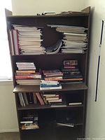 Bookshelf with stacks of books, books visible include historical and regional topics.