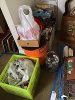 Photo of several containers including binders, boxes, a green plastic crate, and an orange bucket holding numerous pogs and collectible discs.