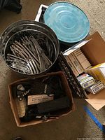 Overview of metal train tracks in a blue and silver container, boxes with unspecified accessories, and a cardboard box filled with train cars and equipment.