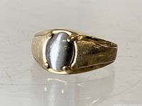 Close-up front view of the 10K gold estate ring showing the oval blue cabochon stone held by four prongs.
