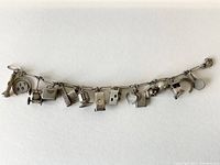 Full view of the antique sterling silver charm bracelet showing all attached charms.