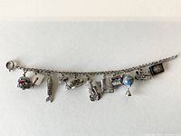 Full view of the sterling silver charm bracelet with all charms visible laid flat.