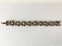 Bracelet laid flat on white background showing full length and bamboo styled links.