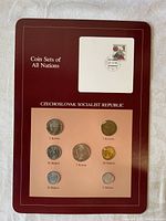 Front side of coin set card displaying 7 coins of various denominations and postally-cancelled stamp from 1984