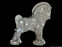 Clear glass Mid Century horse figurine against black background, shows full side profile and glossy finish.