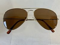 Front view of vintage aviator sunglasses showing brown glass lenses and gold-tone metal frame