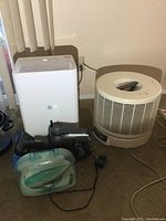 Overall lot showing GE dehumidifier, Honeywell air purifier, iRobot hand vacuum, and Panasonic iron.