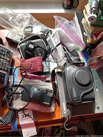 Four cameras including Canon G11, two Nikon Coolpix S5200, and Olympus Infinity Jr on table with accessories.