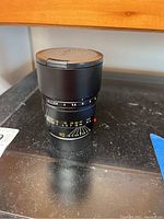 Lens in upright position with hood extended showing aperture and focus markings