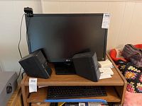 LG Flatron EB2442T monitor with Bose MediaMate speakers and keyboard on wooden stand including some small accessories.