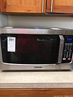 Front view of Toshiba microwave oven showing control panel, door window, and digital display.