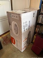 Boxed Stile Anderson 22-inch enclosed ceiling fan still sealed in original packaging, showing brand and model details.