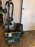 Photo showing three vacuum units: Rainbow Power Nozzle upright vacuum, Rainbow E Series canister vacuum, and Bissell Little Green Clean Machine. Units are dusty and show signs of use.