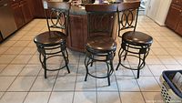 Three swivel bar stools with metal frames and dark brown cushioned seats arranged on kitchen floor.