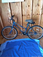 Side view of Magna 20-inch bicycle showing the entire frame, wheels, seat, and pedals indoors on a wood floor.
