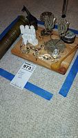 Photo of the lot showing multiple crystal animal figurines, metal wire candle holders, monkey figurine, wooden spoon, small metal cup and metal trinket box arranged on a wooden tray.