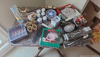Wide view of the table showing all items including napkin rings, tea cups, plates, trays, utensils, chop sticks, and gift box spreader knives.