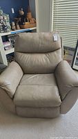 Front view of the beige leather recliner chair showing overall condition and upholstery.